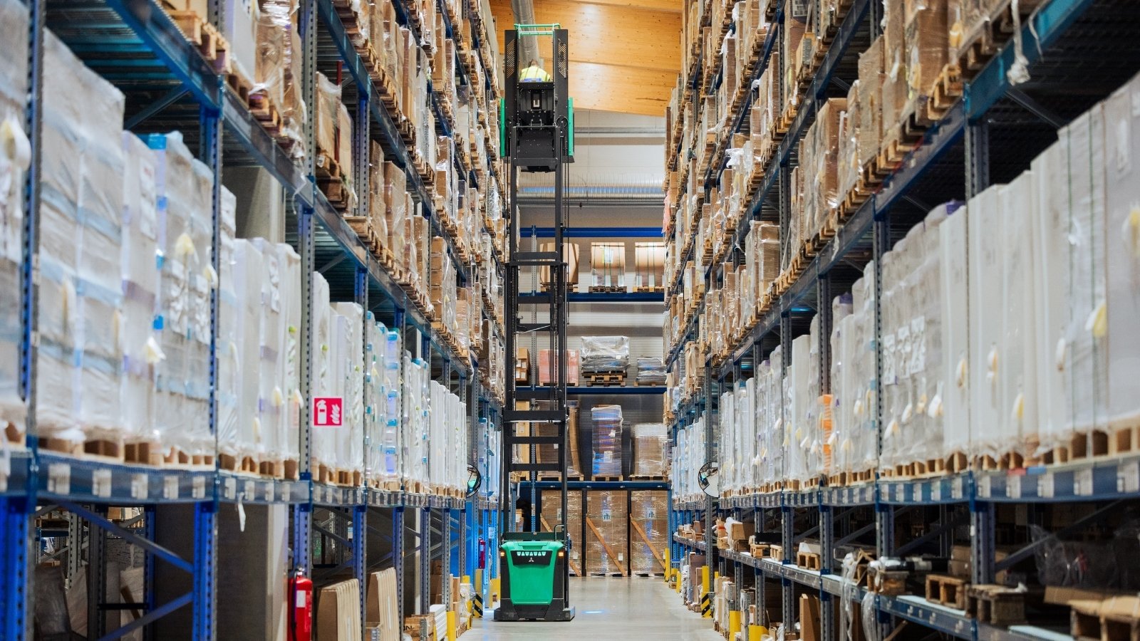 Logentin työntekijä kerää tuotteita varastohyllystä osana tilausten käsittelyä modernissa logistiikkakeskuksessa.